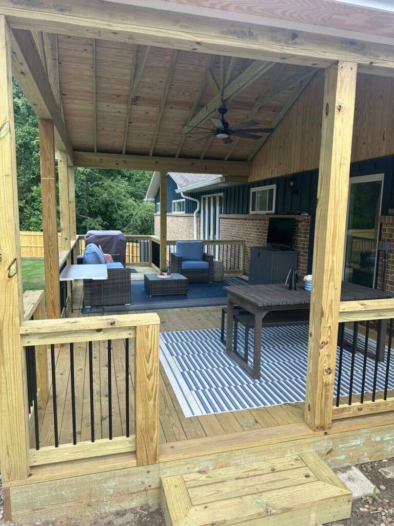 Covered backyard deck transformation in Bluff Park featuring a fully covered outdoor living space with modern railing, ambient lighting, and ceiling fan, perfect for year-round outdoor relaxation and entertaining