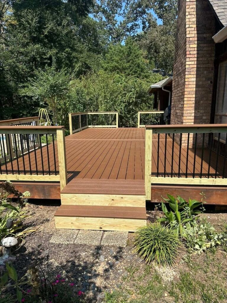 Modern Trex composite deck construction project under construction with warm-toned boards and sleek black railing, showcasing a durable, low-maintenance outdoor living space nearly ready for finishing in Helena, Alabama