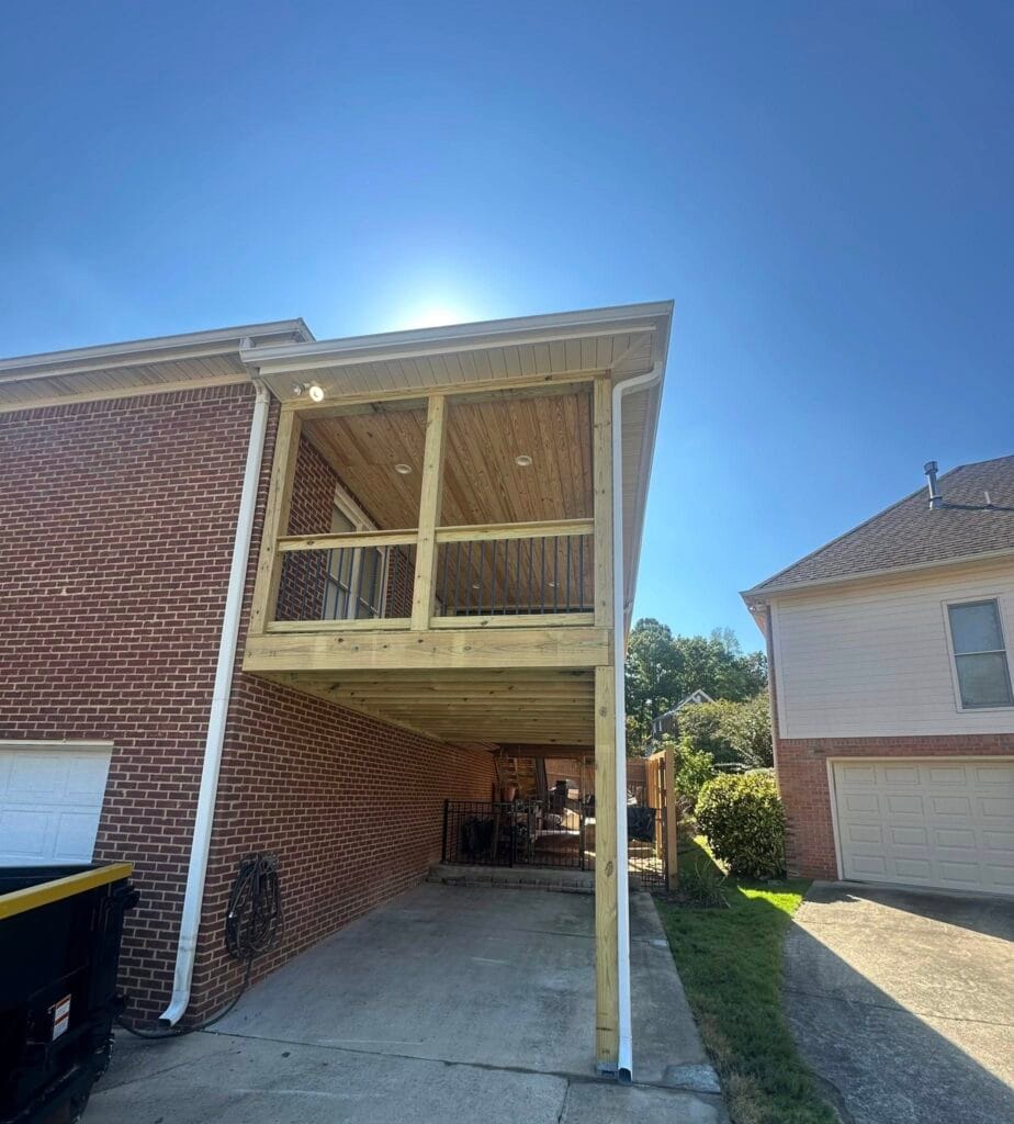 Covered backyard deck construction project with tongue-and-groove ceiling, recessed LED lighting, and gutter system, transforming a former open deck into a comfortable all-season outdoor living space in Helena, Alabama