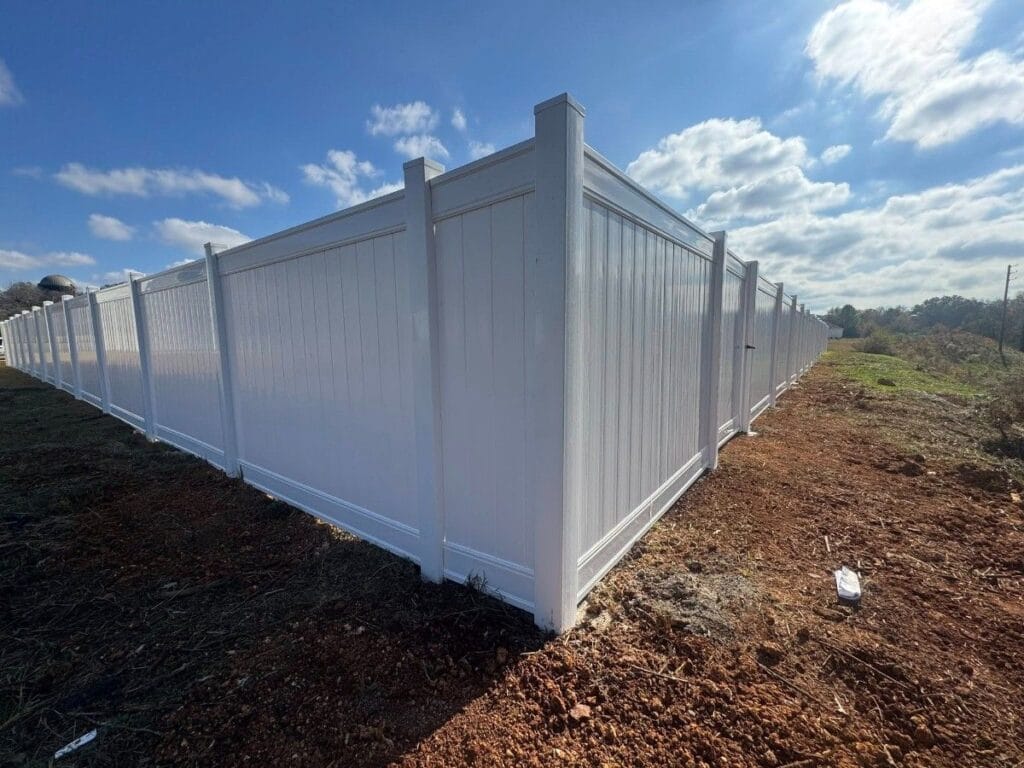 White vinyl privacy fence installed around a residential yard in Calera, Alabama, providing a clean, durable, and low-maintenance boundary for added privacy.