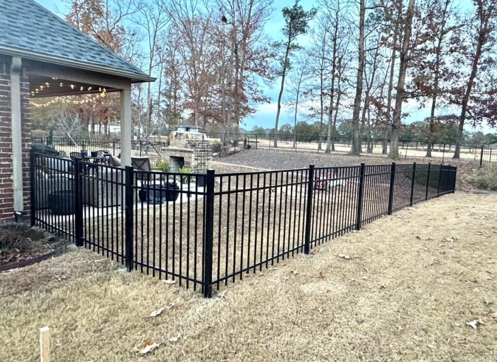 Black aluminum backyard fence installation near Helena Alabama, providing a clean, modern boundary while maintaining an open view, creating a safe and low-maintenance space for kids and pets.