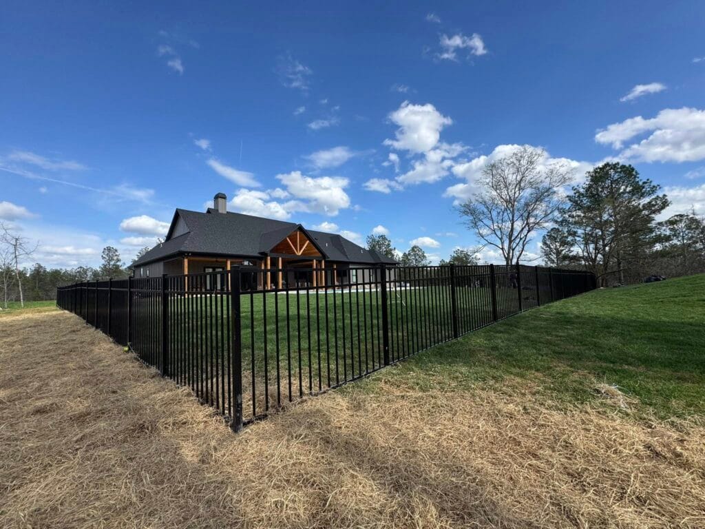 Black aluminum fence installation in Helena, Alabama backyard, showcasing a clean, modern, low-maintenance design that provides security while maintaining an open view—durable, rust-resistant fencing ideal for pets, kids, and pools in changing weather conditions.